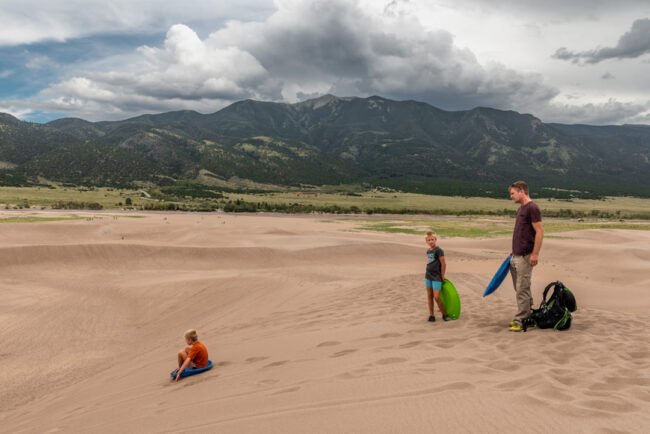 Děti bobujou na dunách - Great Sand Dunes